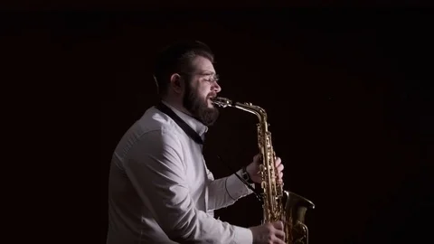 Handsome man playing the saxophone, black background, isolated, solo Stock-Footage 127054558