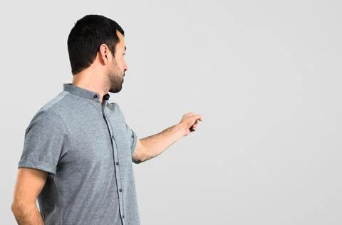 Handsome man pointing back on grey background Stock Photos