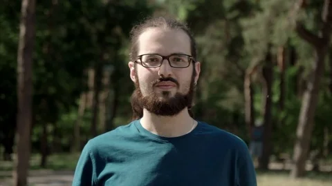 Handsome man portrait looking at camera. Face with beard and eyeglasses Stock Footage 76771719