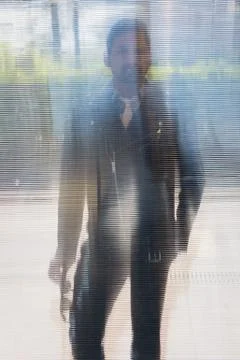 Handsome man posing behind a plastic panel Stock Photos