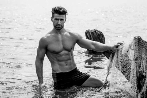 Handsome man is posing in the river. Foto stock