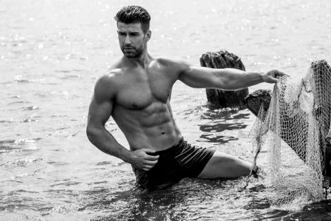 Handsome man is posing in the river. Foto stock