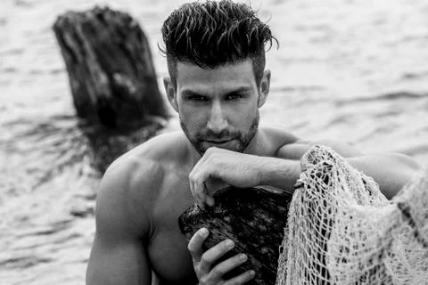 Handsome man is posing in the river. Stock Photos