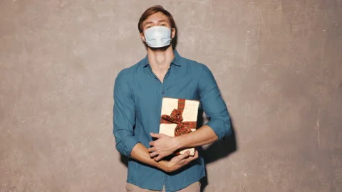 Handsome man posing in studio with gift box in hands Stock Footage 146133577