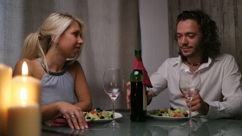 Handsome man is pouring wine on a date Stock Footage 104915565