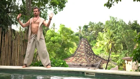 Handsome man practice qigong exercises on summer terrace near the pool Stock Footage 133630356