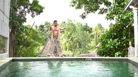 Handsome man practice qigong exercises on summer terrace near the pool Vídeos de archivo 133630603
