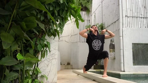 Handsome man practice yoga in summer terrace near swimming pool Stock Footage 133630490