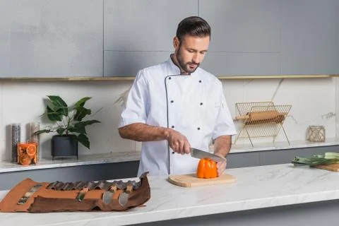 Handsome man preparing salad in kitchen. Stock Photos
