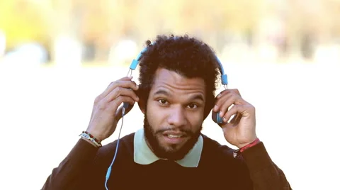 Handsome man putting on headphones and listening to music Stock Footage 59555295