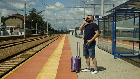 Handsome man quarrelling on cellphone while standing on the platform Stock Footage 78655983