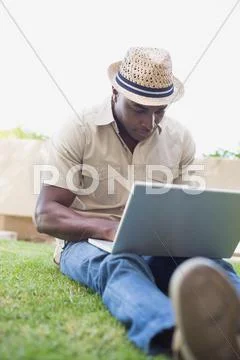 Handsome man relaxing in his garden using laptop Stock-Fotos