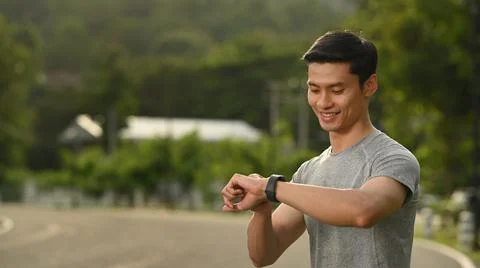 Handsome man resting and checking his heart rate data on smartwatch during Stock Photos
