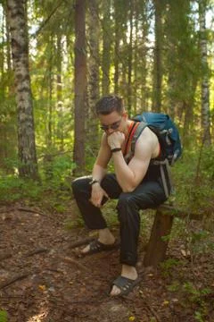 Handsome man resting on  bench in  spring forest Stock Photos