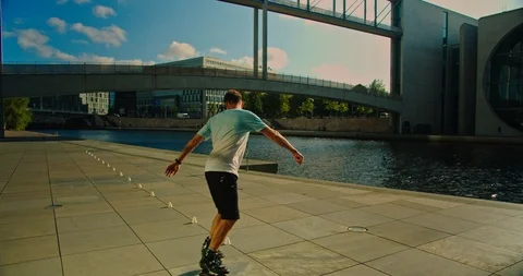 Handsome man on roller skates doing beautiful tricks and spins in city location  Stock Footage 117469406