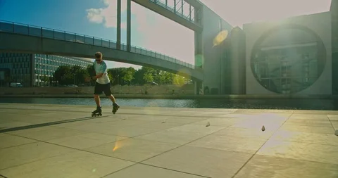 Handsome man on roller skates doing beautiful tricks and spins in city location  Stock Footage 117469748