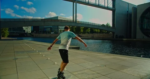 Handsome man on roller skates doing beautiful tricks and spins in city location  Stock Footage 117469846