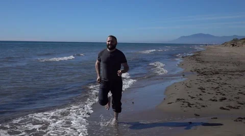 Handsome man running by sea Stock Footage 57738243