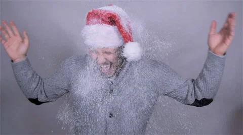 Handsome man in santa claus hat enjoying snow, slow motion. Stockbeeldmateriaal 44455654