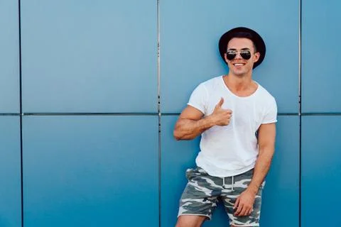 Handsome man showing a thumb up while posing at camera, outdoors Stock Photos