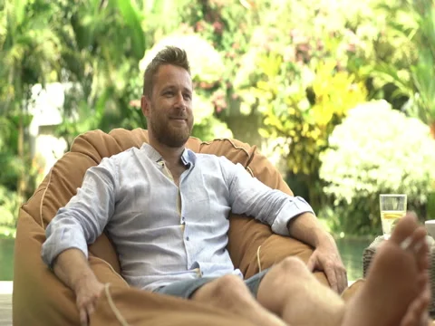 Handsome man showing thumbs to the camera and relaxing on bean bag chair Stock-Footage 79224508