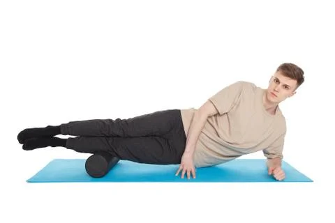 Handsome man shows exercises using a foam roller Stock Photos