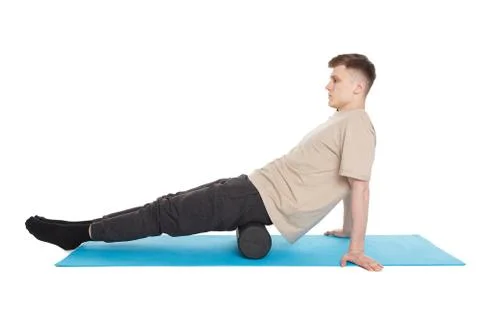 Handsome man shows exercises using a foam roller Stock Photos