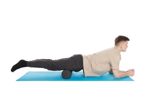 Handsome man shows exercises using a foam roller Stock Photos