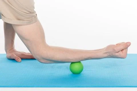 Handsome man shows exercises using the ball with spikes Photos