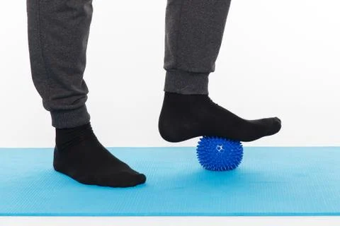 Handsome man shows exercises using the ball with spikes Fotos de archivo