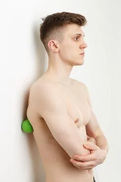 Handsome man shows exercises using the ball with spikes Fotos de archivo