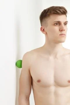 Handsome man shows exercises using the ball with spikes Stock Photos