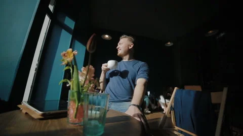 The handsome man sits in cafe and has a rest Stock Footage 62549690