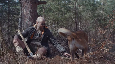 Handsome Man Sitting and Resting After Hardwork in The Forest With His Dog Stock Footage 87534971
