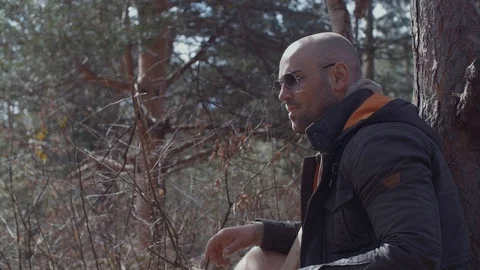 Handsome Man Sitting and Resting After Hardwork in The Forest With His Dog Stock Footage 87535654