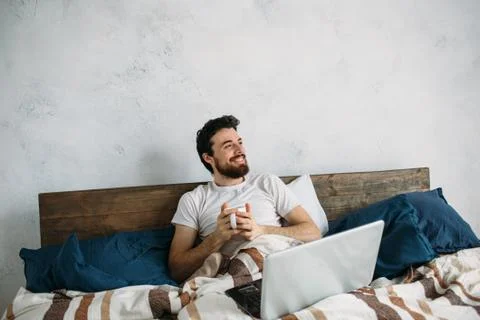 Handsome man sitting in bed Stock Photos