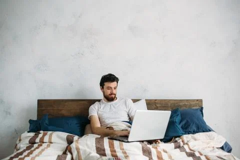 Handsome man sitting in bed Foto stock