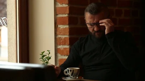 Handsome man sitting in the cafe and having painful headache Video stock 80423900