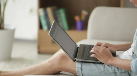 Handsome man sitting on couch and using laptop Video stock 27692003