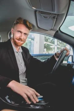 Handsome man sitting inside electro car. Stock Photos
