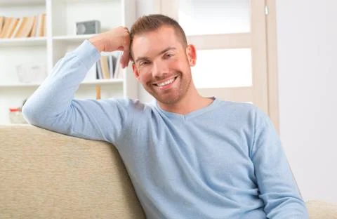 Handsome man sitting on the sofa Stock Photos