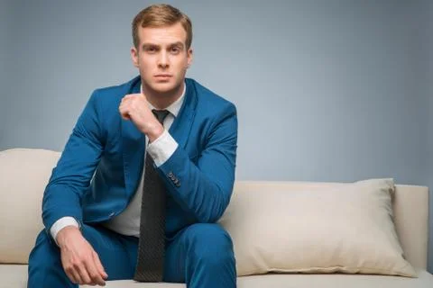 Handsome man sitting on the sofa Stock Photos