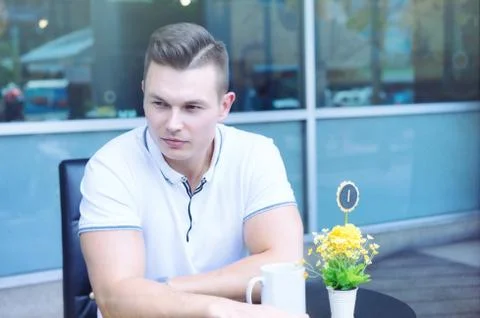 Handsome man sitting at table looking away and thinking. Stock-Fotos