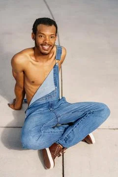 Handsome man sitting with unbuttoned overalls Stock Photos