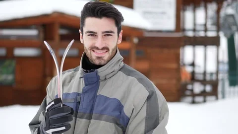 Handsome man with ski standing in snow Stock Footage 84763857
