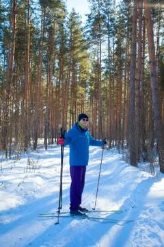 Handsome man with skis in  winter forest Stock Photos