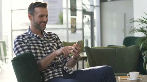 Handsome man with smartphone sitting at cafe Stock Footage 70810054