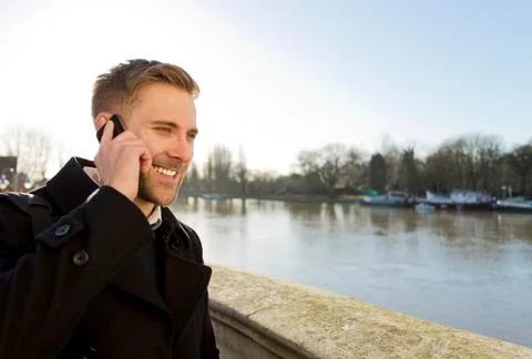 Handsome man smiling and talking mobile cell phone Stock Photos