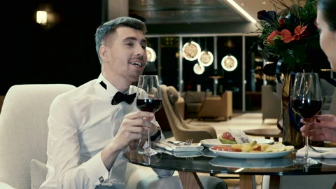 The handsome man smiling, talking with his girlfriend and drinking red wine. 4K Stock Footage 88801512