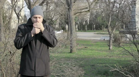 Handsome man smokes at a park Video stock 59856986